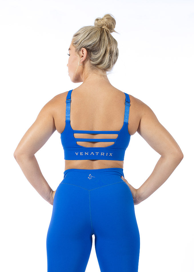 Back view of a blue sports bra for women featuring adjustable straps, racerback design, and breathable VenaLux fabric.